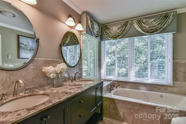 a bathroom with a granite countertop sink mirror and bathtub