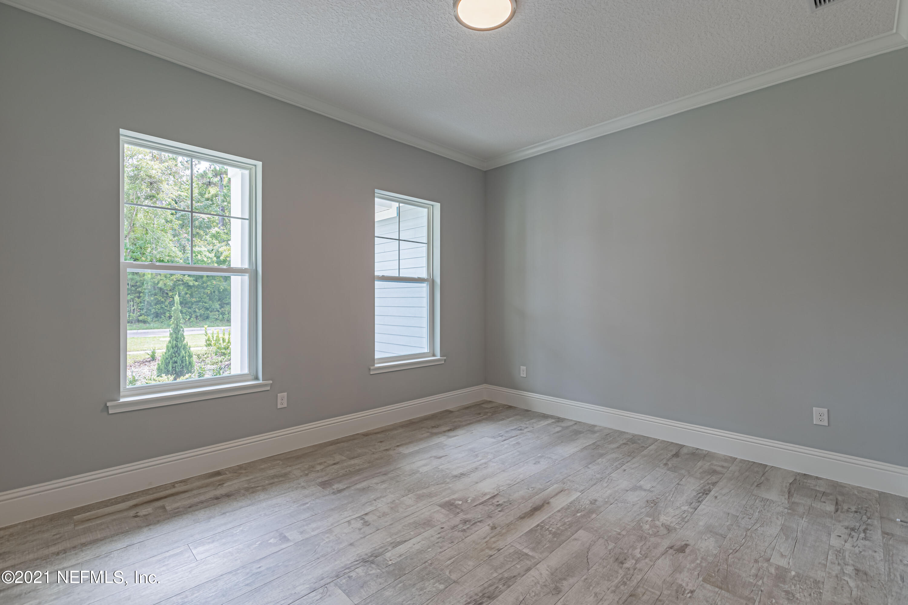 1351 Weaver Glen Road Jacksonville, FL 32223 - Photo 23 of 30 an empty room with wooden floor and windows