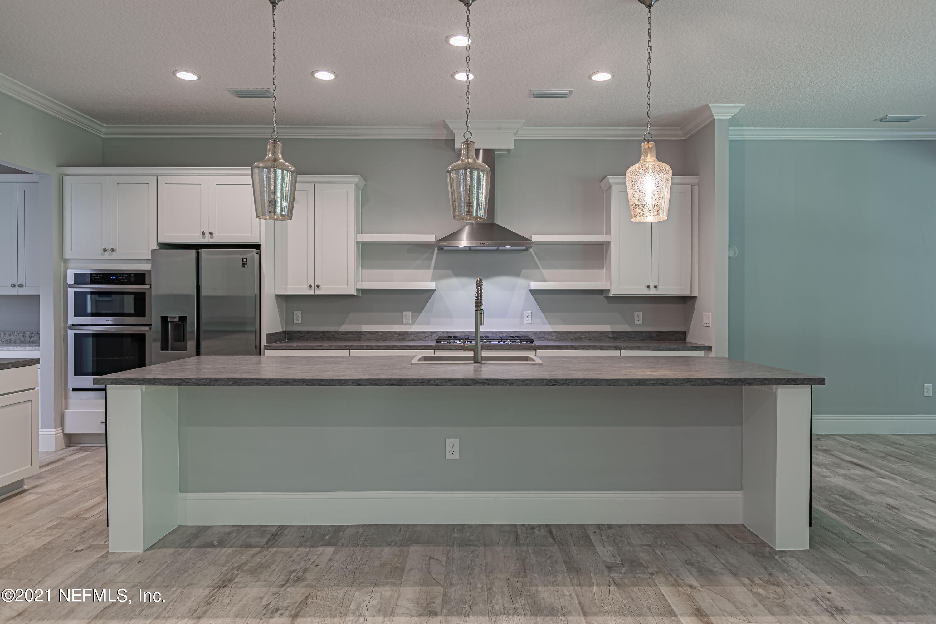 1351 Weaver Glen Road Jacksonville, FL 32223 - Photo 7 of 30 a large kitchen with stainless steel appliances a large counter top a stove and a refrigerator