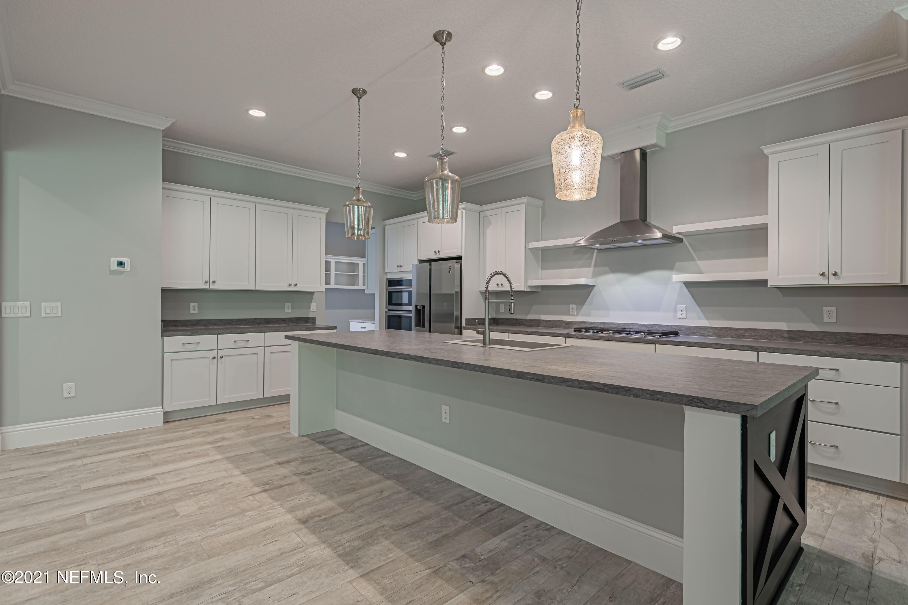 1351 Weaver Glen Road Jacksonville, FL 32223 - Photo 9 of 30 a large kitchen with granite countertop a large kitchen island white cabinets and stainless steel appliances