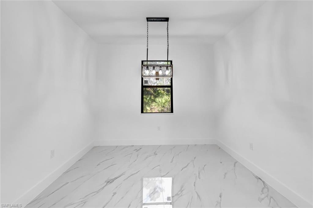 2113 Grayson Avenue Alva, FL 33920 - Photo 10 of 25 Unfurnished dining area featuring baseboards and light marble finish flooring