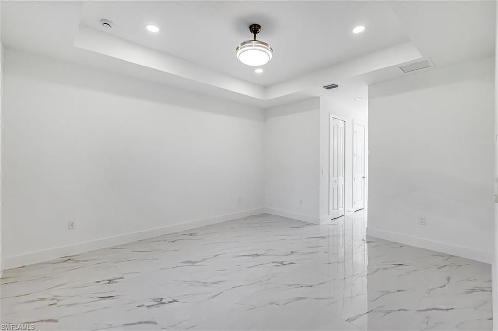 2113 Grayson Avenue Alva, FL 33920 - Photo 11 of 25 Spare room featuring a raised ceiling, recessed lighting, and light marble finish floors