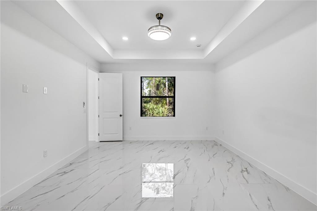2113 Grayson Avenue Alva, FL 33920 - Photo 12 of 25 Empty room with light marble finish flooring, a tray ceiling, and recessed lighting