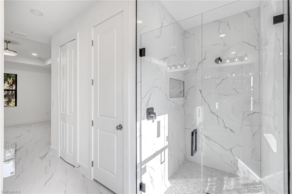 2113 Grayson Avenue Alva, FL 33920 - Photo 14 of 25 Bathroom featuring a marble finish shower, light marble finish floors, recessed lighting, and a closet