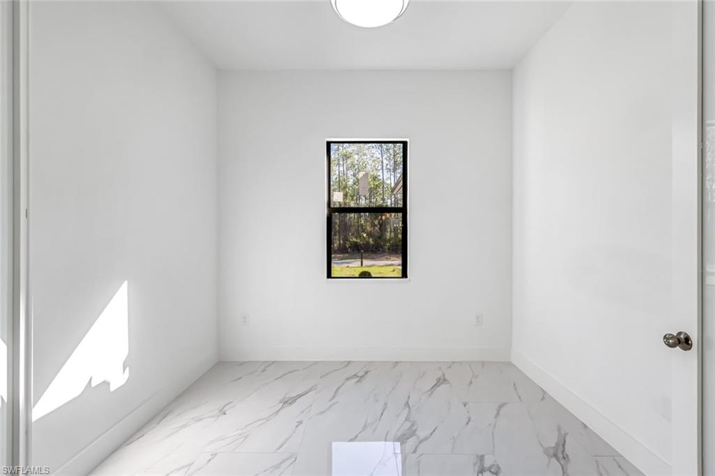 2113 Grayson Avenue Alva, FL 33920 - Photo 18 of 25 Empty room featuring light marble finish floors and baseboards