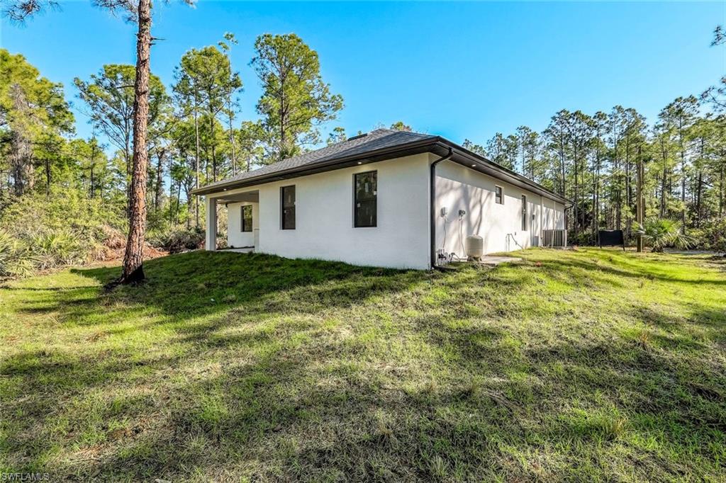 2113 Grayson Avenue Alva, FL 33920 - Photo 24 of 25 View of home's exterior with a lawn and stucco siding