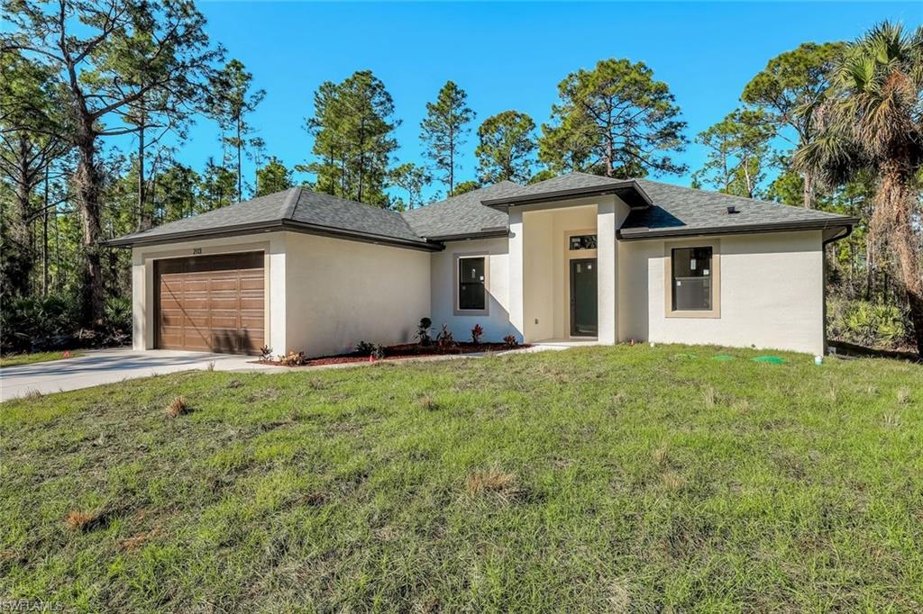2113 Grayson Avenue Alva, FL 33920 - Photo 3 of 25 Prairie-style home featuring a front yard, stucco siding, a garage, driveway, and a shingled roof