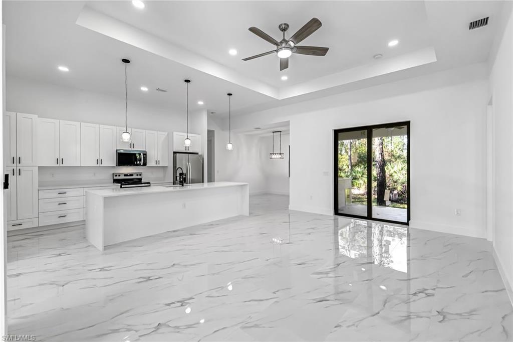 2113 Grayson Avenue Alva, FL 33920 - Photo 25 of 25 Kitchen with open floor plan, a center island with sink, white cabinetry, pendant lighting, and a ceiling fan