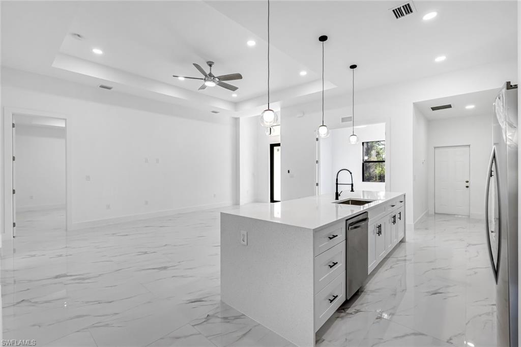 2113 Grayson Avenue Alva, FL 33920 - Photo 6 of 25 Kitchen featuring white cabinets, light stone countertops, pendant lighting, a ceiling fan, and stainless steel appliances