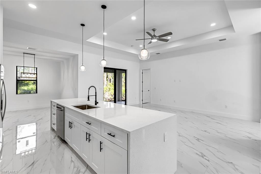 2113 Grayson Avenue Alva, FL 33920 - Photo 7 of 25 Kitchen with hanging light fixtures, white cabinetry, light stone countertops, a tray ceiling, and a kitchen island with sink