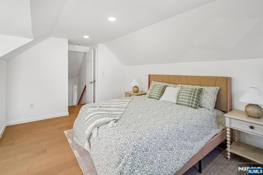 127 Village Circle West Paramus, NJ 07652 - Photo 20 of 46 a bedroom with a bed and wooden floor