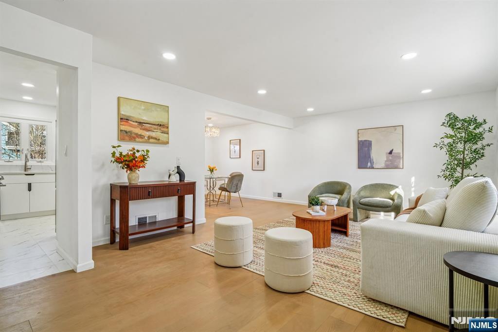 127 Village Circle West Paramus, NJ 07652 - Photo 5 of 46 a living room with fireplace furniture and paintings on the wall