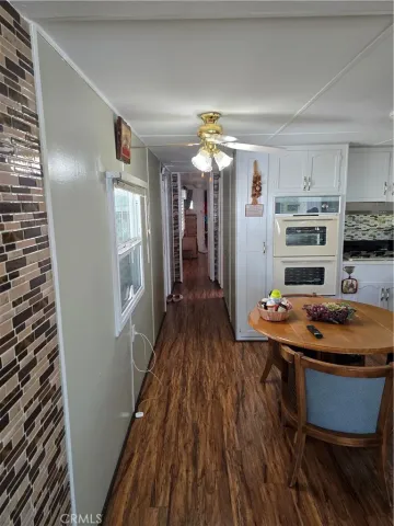 a room with wooden floor table and chairs