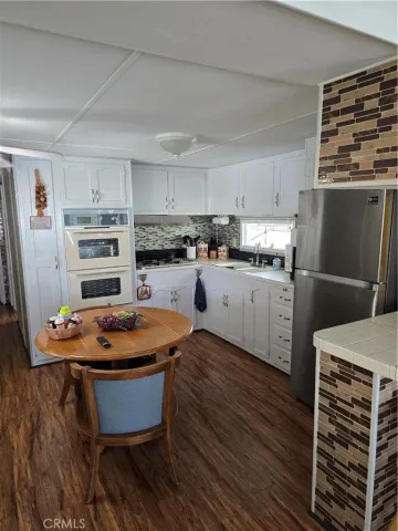 a kitchen with stainless steel appliances a stove refrigerator sink and cabinets