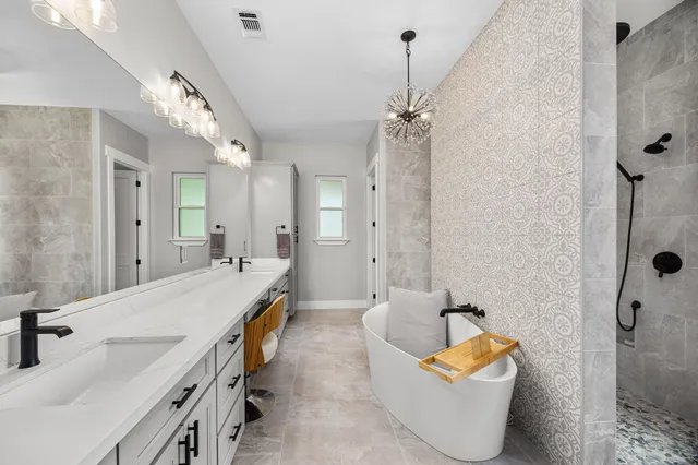 a spacious bathroom with a tub sink and mirror
