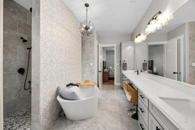 a spacious bathroom with a tub a sink and mirror