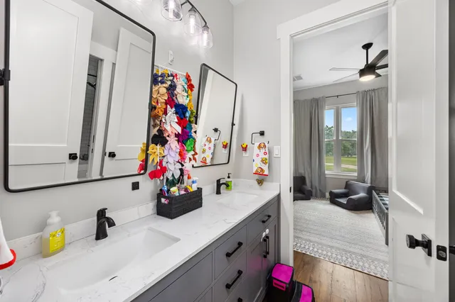 a bathroom with a sink vanity mirror and a window