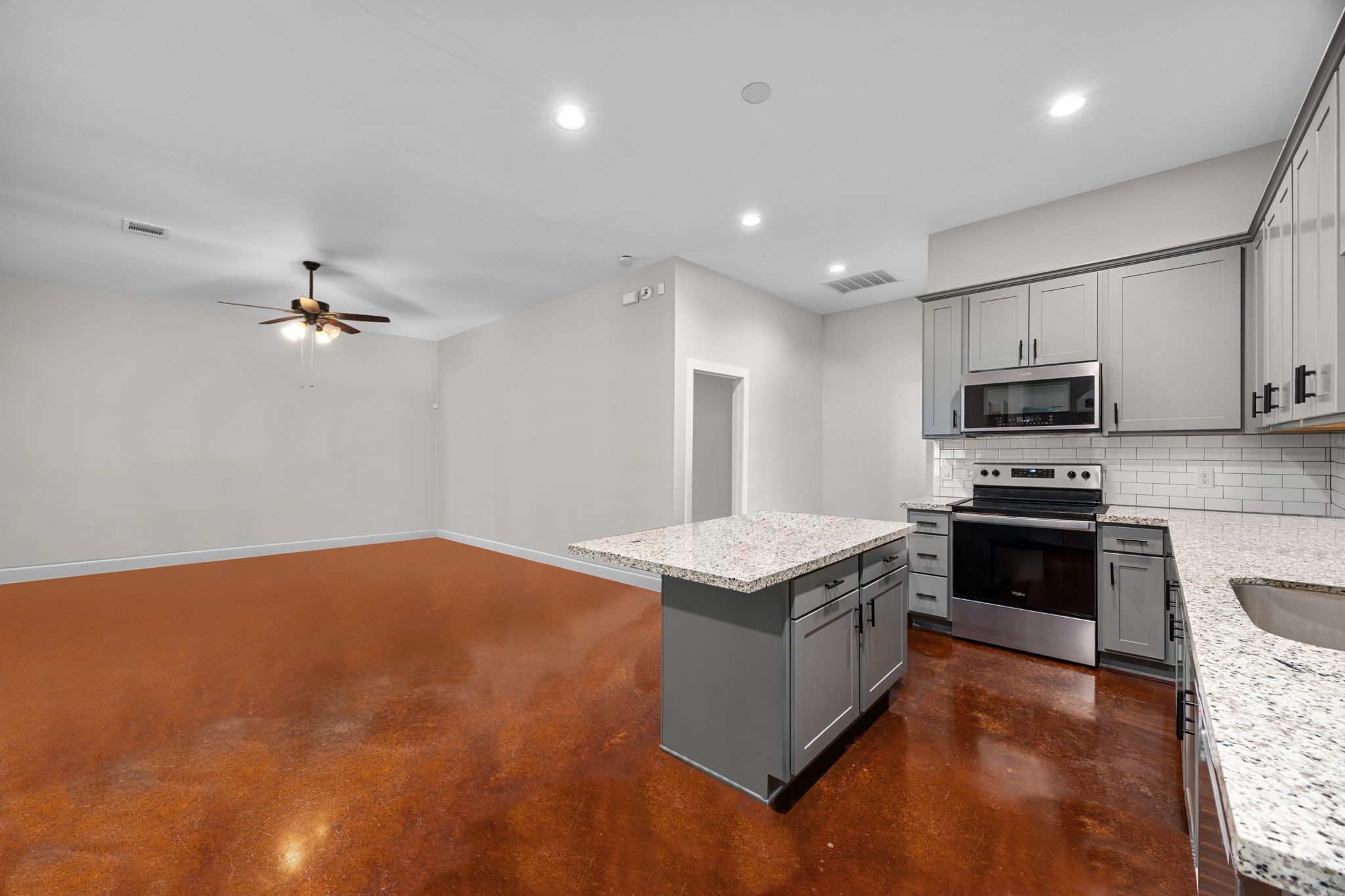 1507 Smith Rau Road Columbus, TX 78934 - Photo 31 of 50 a kitchen with kitchen island a stove a sink and a microwave