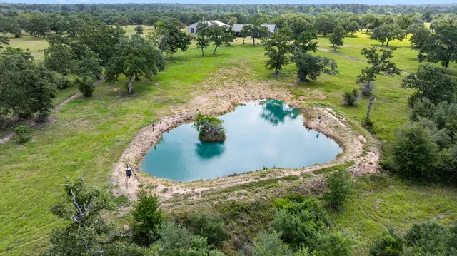 an aerial view of a house with a yard and lake view