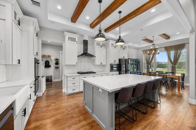 a large kitchen with kitchen island a large island in the center and stainless steel appliances