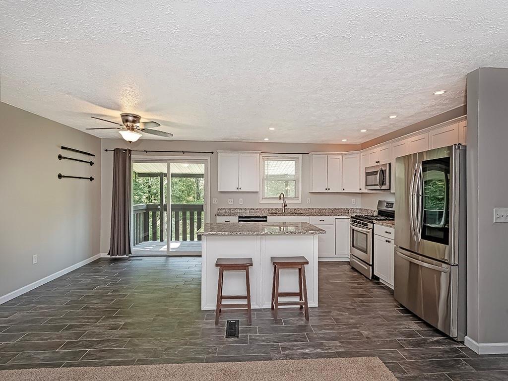 516 South Eberhart Road Butler, PA 16001 - Photo 12 of 31 a kitchen with stainless steel appliances granite countertop a stove top oven a sink refrigerator and cabinets