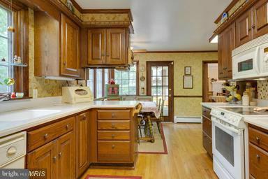 6609 Robin Road Springfield, VA 22150 - Photo 9 of 28 a kitchen with stainless steel appliances granite countertop a stove a sink dishwasher and cabinets with wooden floor