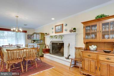 6609 Robin Road Springfield, VA 22150 - Photo 10 of 28 a living room with furniture a dining table and a fireplace