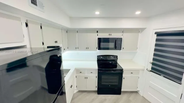 a kitchen with a refrigerator and a stove top oven
