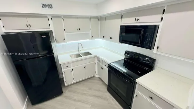 a kitchen with a sink and a stove top oven