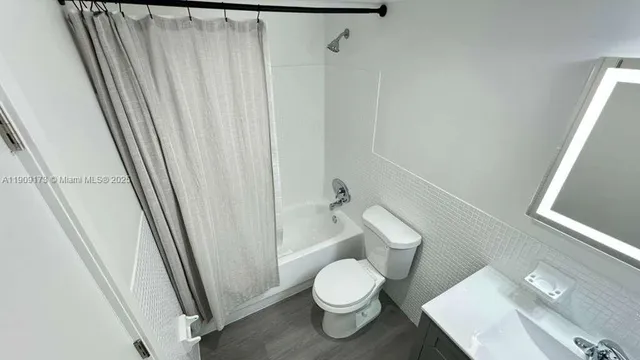 a white toilet sitting next to a sink
