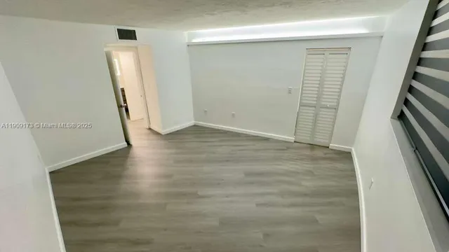 an empty room with wooden floor and entrance