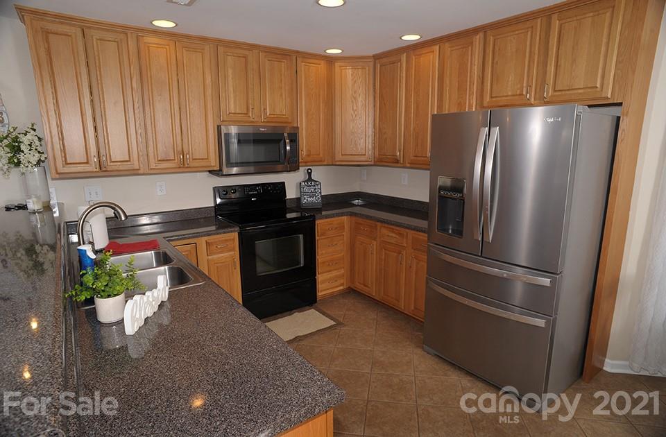 2396 Sides Road Rockwell, NC 28138 - Photo 8 of 20 a kitchen with stainless steel appliances granite countertop a refrigerator a sink a stove with wooden cabinets