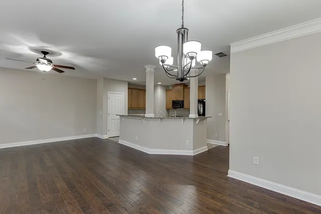 a view of a room with wooden floor and ceiling fan