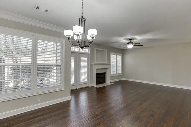 a view of a livingroom with a chandelier wooden floor fireplace and chandelier