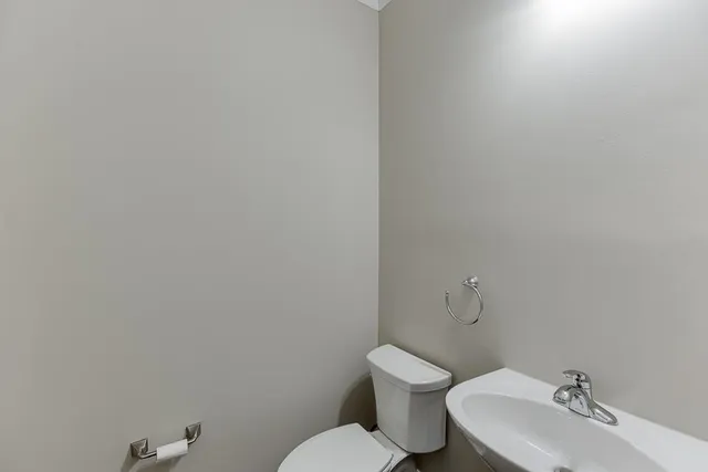 a white toilet sitting next to a white sink and vanity