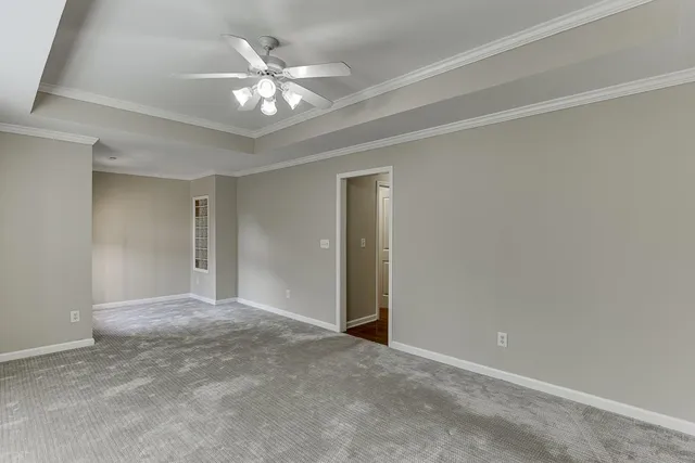 a view of an empty room with a chandelier fan