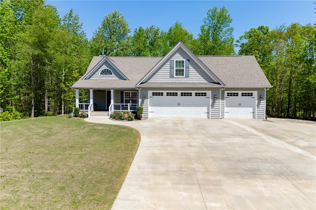 7660 Fern Lane Lula, GA 30554 - Photo 46 of 50 a house with lots of trees in the background