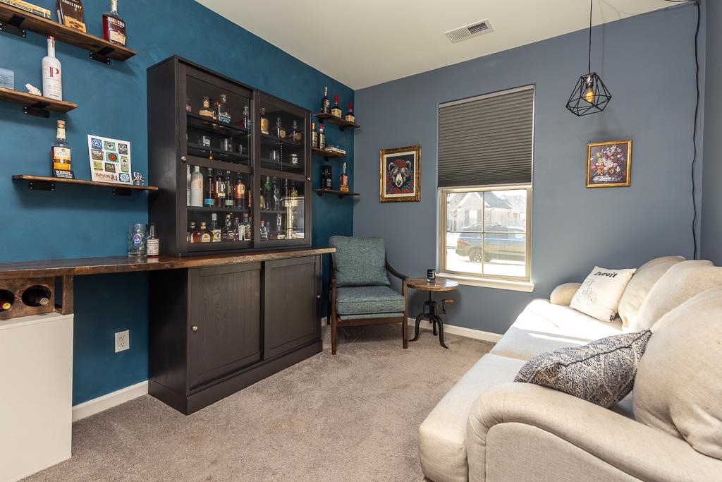 95 Chesnut Rdg Drive Oakland, TN 38060 - Photo 19 of 33 Living area with light colored carpet and a bar