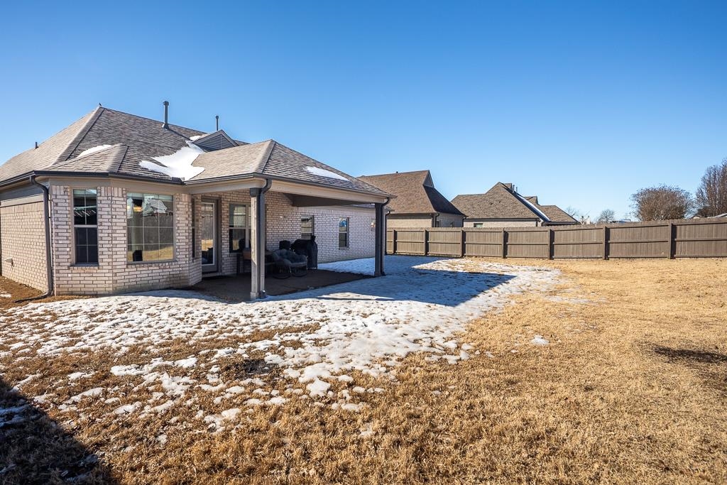 95 Chesnut Rdg Drive Oakland, TN 38060 - Photo 28 of 33 Snow covered house featuring brick siding, a patio area, a fenced backyard, and a shingled roof