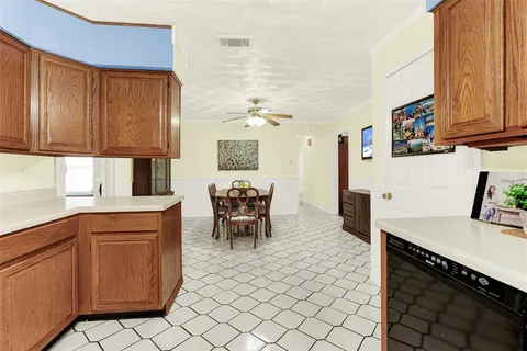 a kitchen with granite countertop a sink cabinets and stainless steel appliances