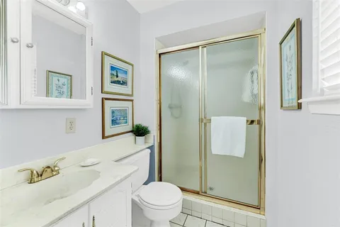 a bathroom with a granite countertop sink a toilet and shower