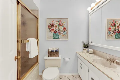 a bathroom with a granite countertop sink mirror vanity and toilet