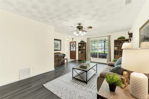 a living room with furniture and wooden floor