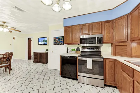 a kitchen with stainless steel appliances a stove a sink a microwave and a refrigerator