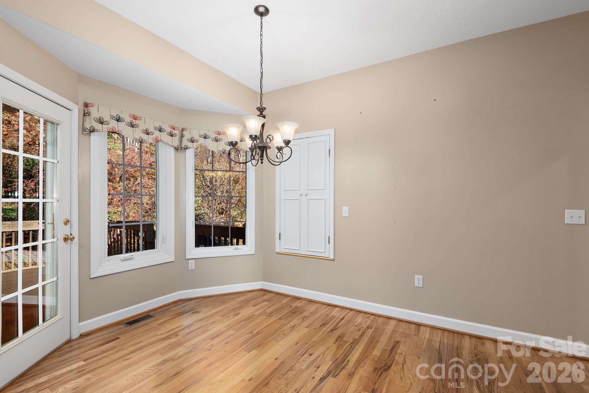 212 Blue Ridge Vista Asheville, NC 28805 - Photo 13 of 42 a view of an empty room with a window and wooden floor