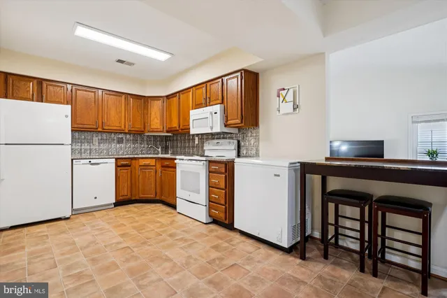 a kitchen with white cabinets and white appliances