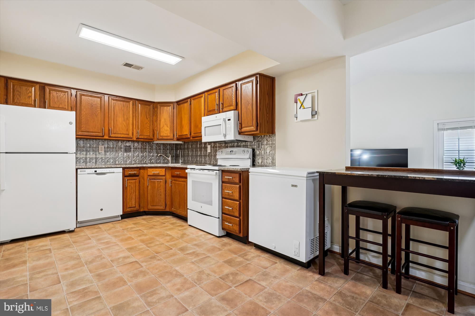 14511 Colonels Choice Road Upper Marlboro, MD 20772 - Photo 12 of 41 a kitchen with white cabinets and white appliances