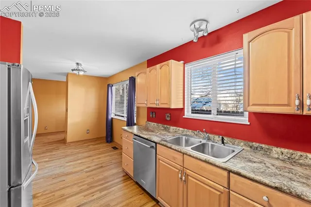 a kitchen with stainless steel appliances granite countertop a sink and wooden cabinets