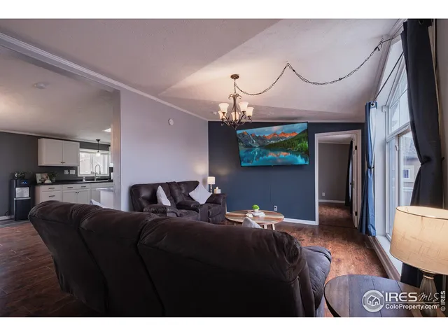 a living room with furniture a chandelier and a flat screen tv