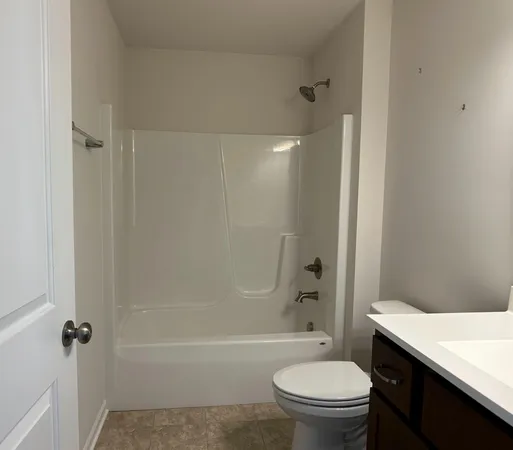 a bathroom with a granite countertop toilet a sink and a bathtub